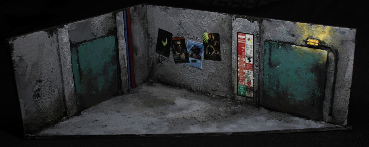 Concrete walls and floor, classic movie posters, caution signs and two pale green metal doors. There's a light over one of them.